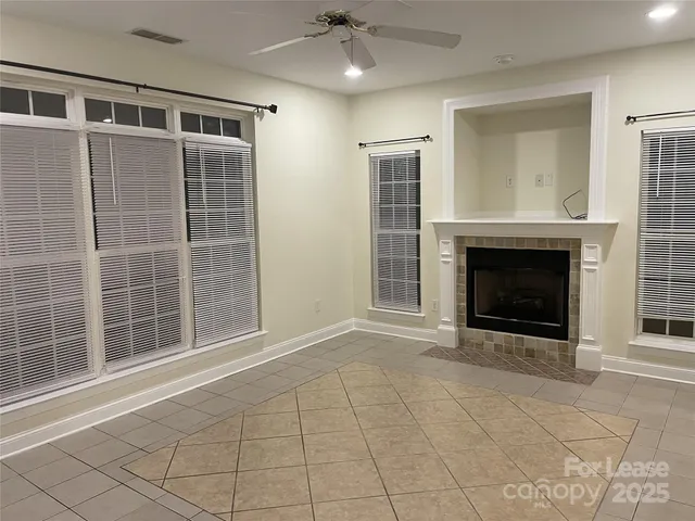 a view of an empty room with a fireplace and a window