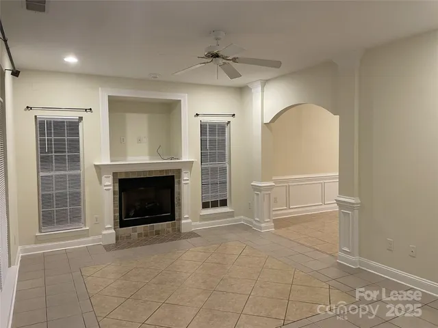 an empty room with fireplace and windows