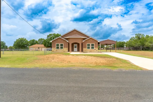 a view of a house with a big yard and large trees