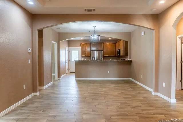 a view of kitchen with stainless steel appliances granite countertop cabinets and wooden floor