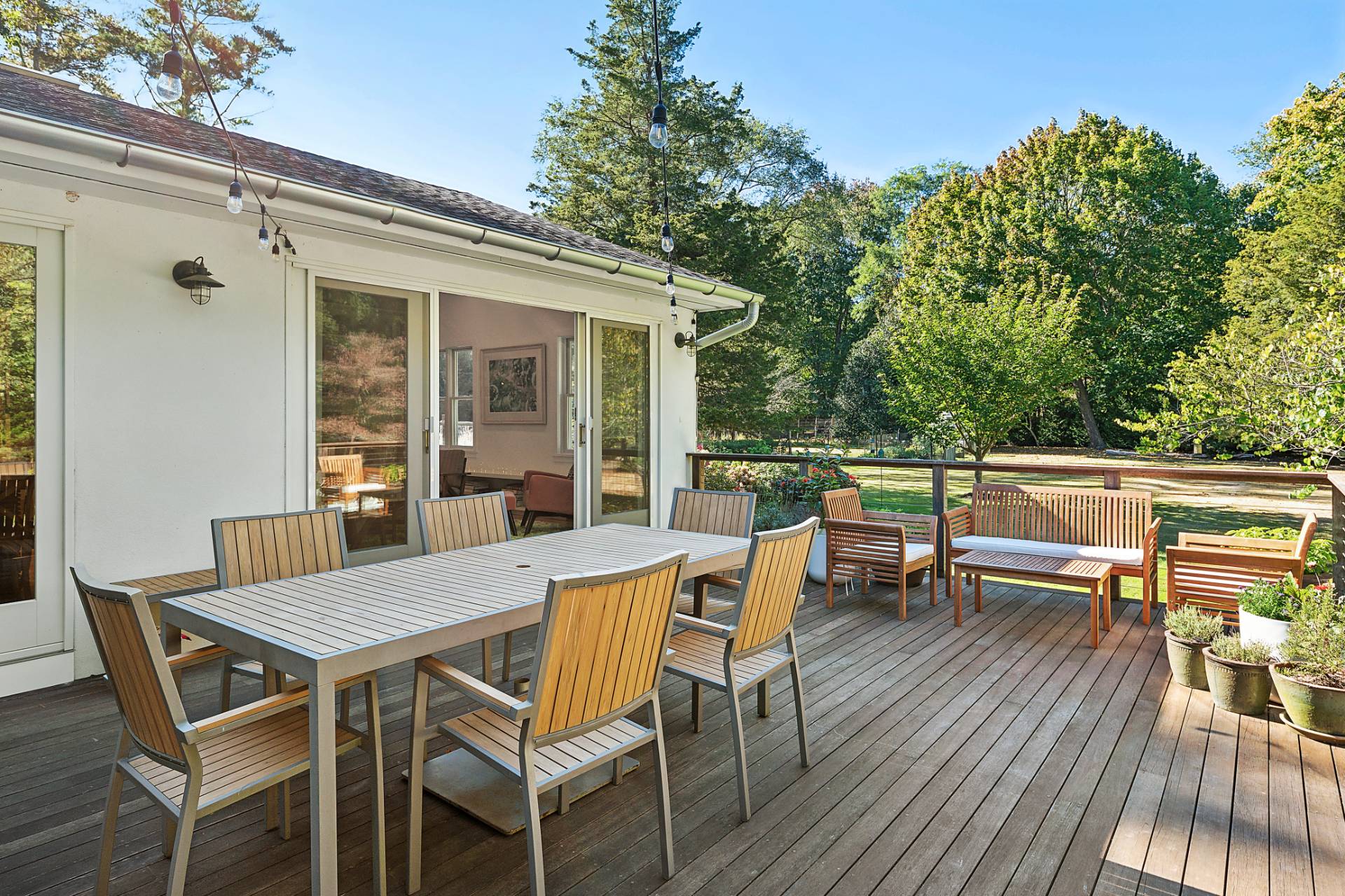 1214 Fireplace Road East Hampton, NY 11937 - Photo 18 of 19 a view of a patio with a dining table and chairs with wooden floor