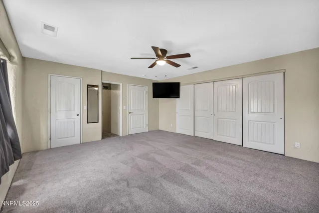 an empty room with windows and flat screen tv