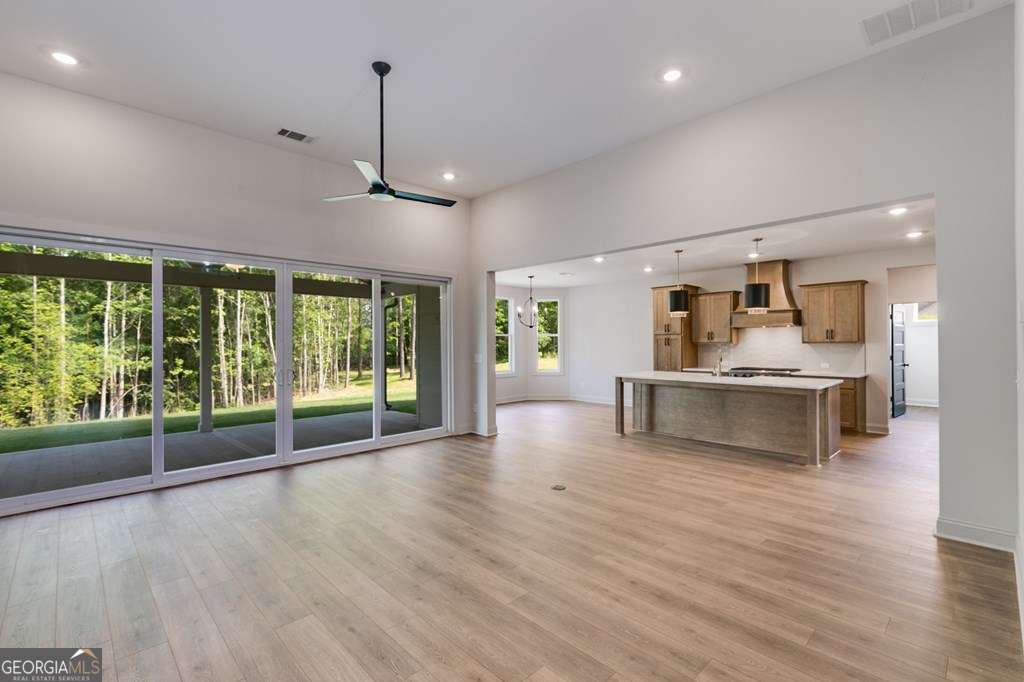 1593 Bethesda Church Road Carrollton, GA 30117 - Photo 11 of 48 a view of an empty room with wooden floor and a kitchen