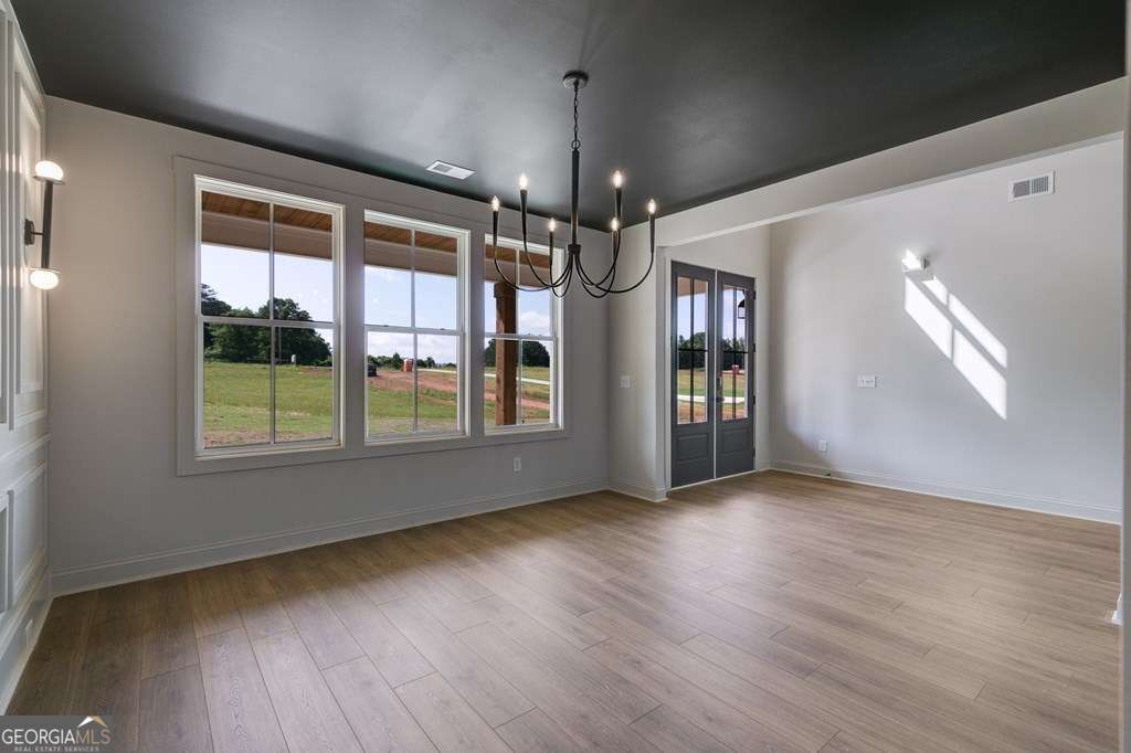 1593 Bethesda Church Road Carrollton, GA 30117 - Photo 8 of 48 a view of an empty room with wooden floor and a window