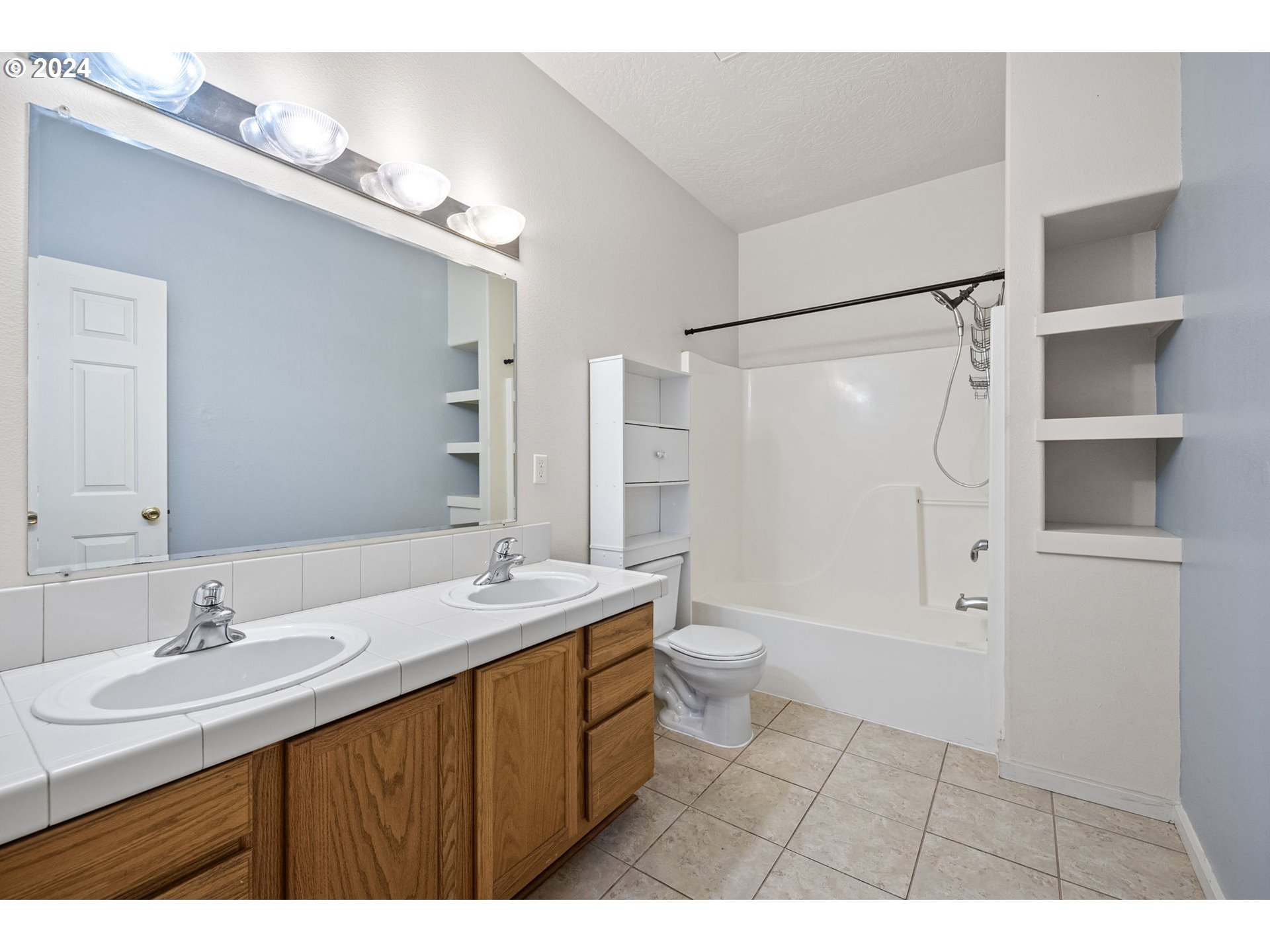 1529 South 59th Street Springfield, OR 97478 - Photo 23 of 38 a bathroom with a sink a toilet a mirror and shower
