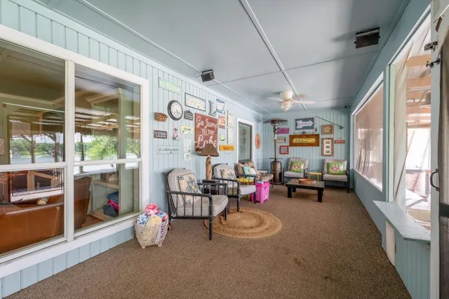 a living room with furniture a flat screen tv and a large window