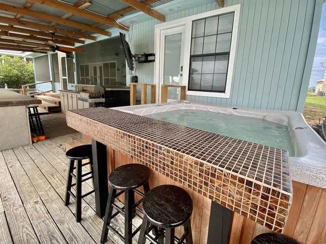 a view of a patio with table and chairs with wooden floor and fence