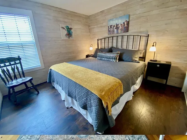 a bed sitting in a bedroom next to a window