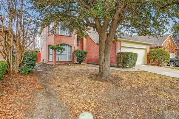 front view of a house with a yard and potted plants