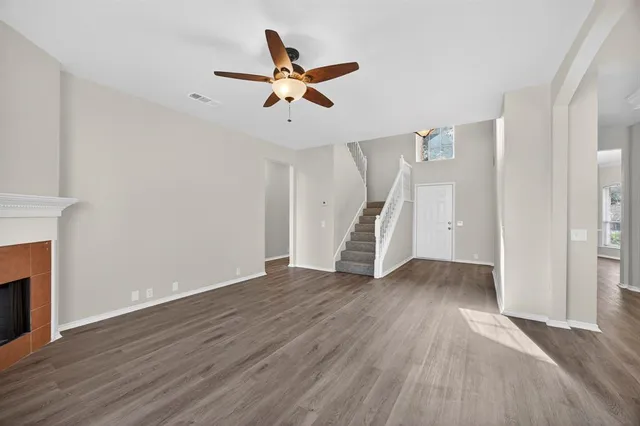a view of empty room with wooden floor and ceiling fan