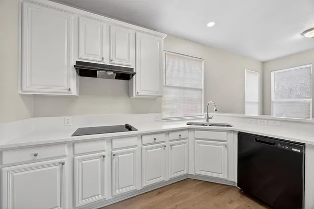 a kitchen with white cabinets and a sink