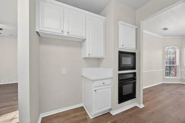a kitchen with white cabinets and a stove