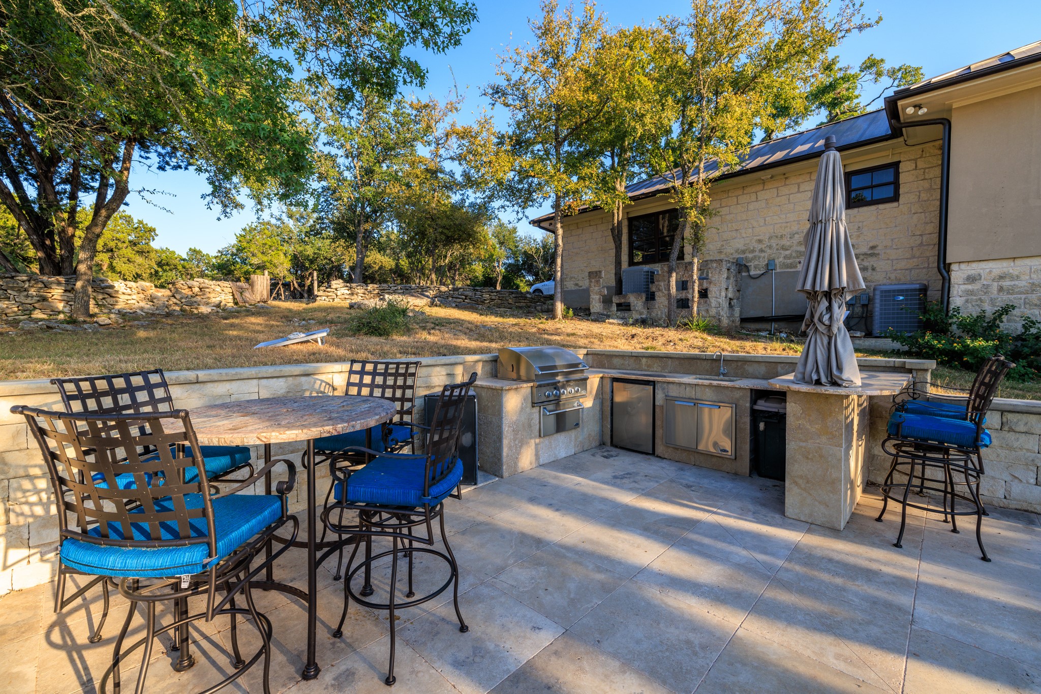 5801 Mount Gainor Road Wimberley, TX 78676 - Photo 11 of 40 a view of a chairs and table in the back yard of the house