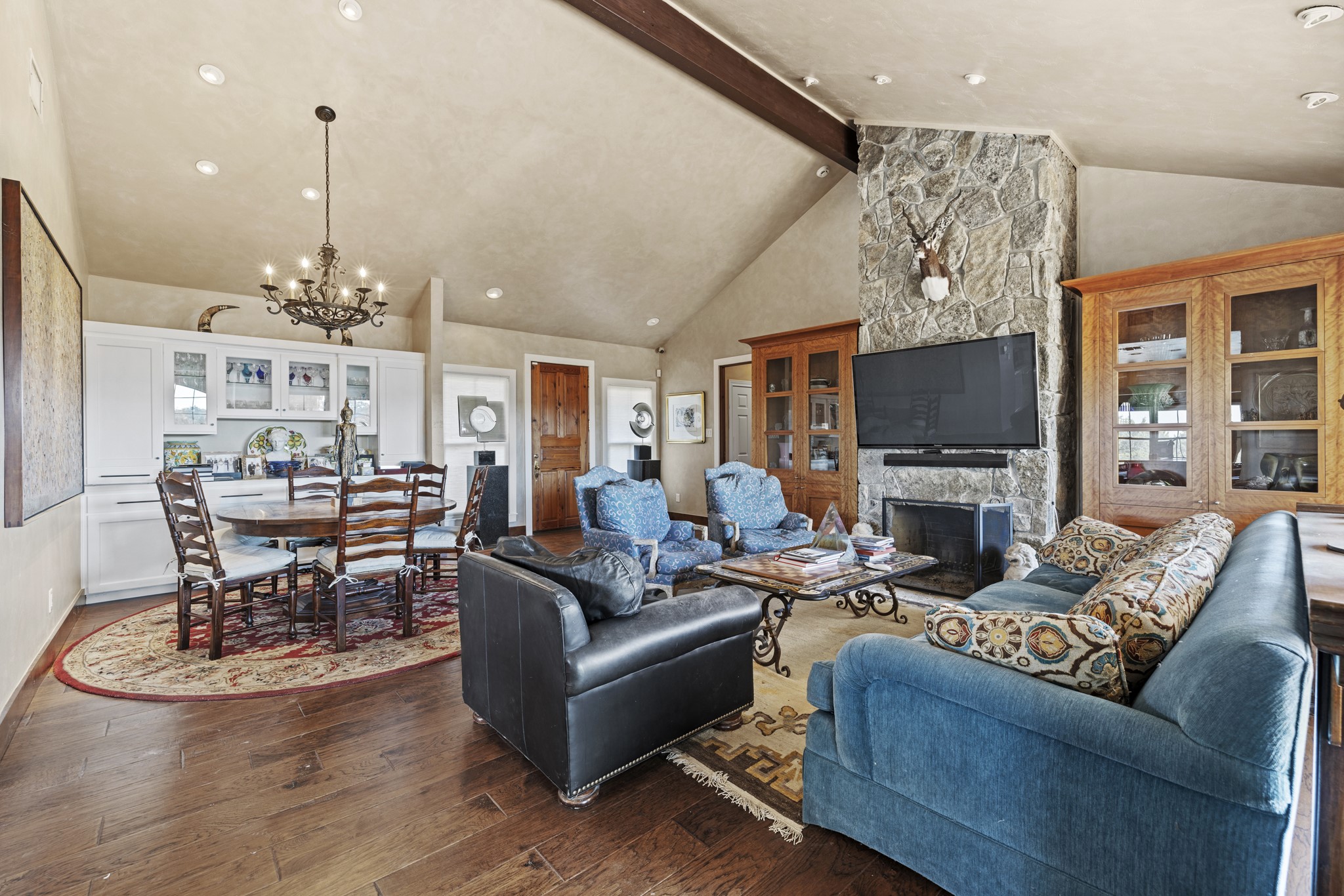5801 Mount Gainor Road Wimberley, TX 78676 - Photo 15 of 40 a living room with furniture a dining table and a chandelier