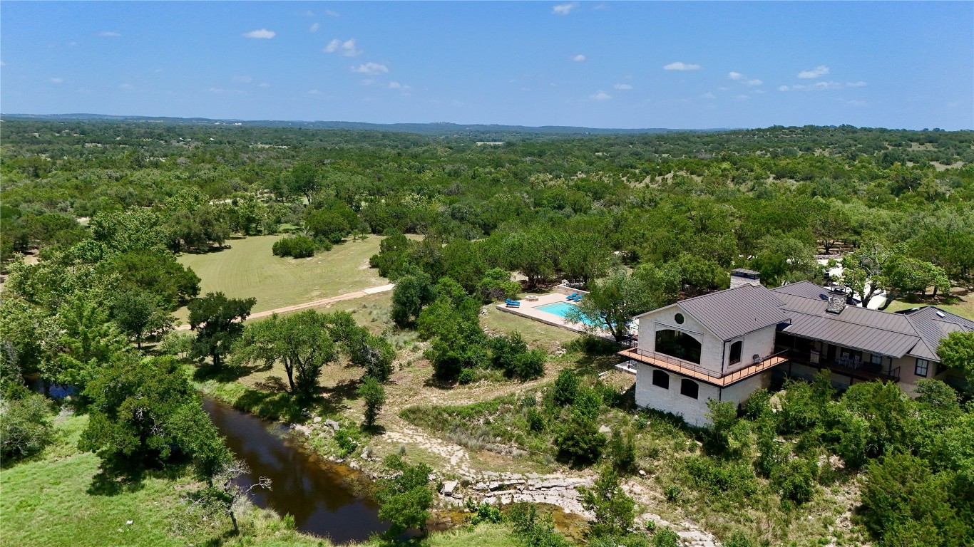 5801 Mount Gainor Road Wimberley, TX 78676 - Photo 7 of 40 Drone / aerial view of a heavily wooded area and a pool