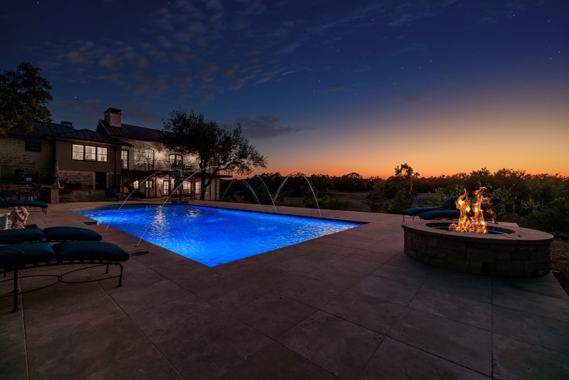 5801 Mount Gainor Road Wimberley, TX 78676 - Photo 10 of 40 Pool at dusk featuring a fire pit, a patio area, and an outdoor pool