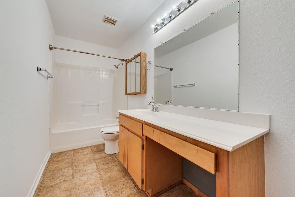 301 Lipscomb Street Cleburne, TX 76031 - Photo 15 of 21 a bathroom with a sink a toilet and shower