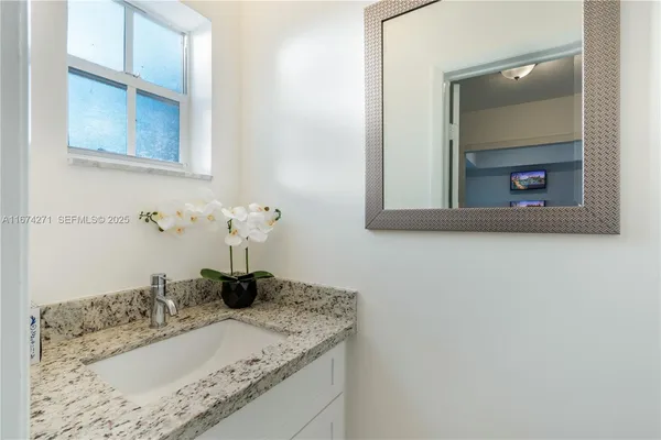 a bathroom with a granite countertop sink a toilet and a mirror