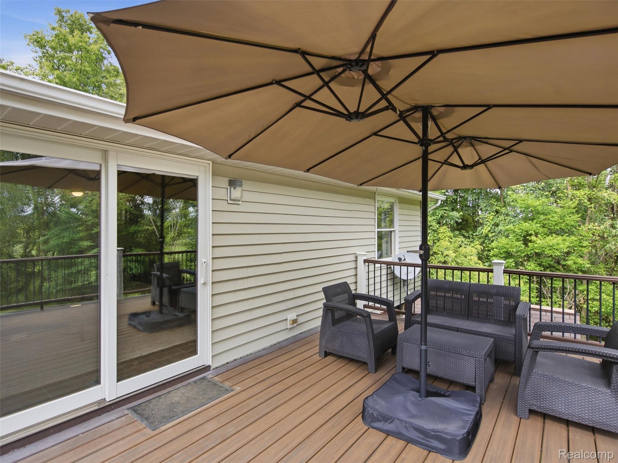 5003 Mason Road Howell, MI 48843 - Photo 43 of 59 Expansive exterior deck featuring wood-finish flooring, a white sliding glass door, and metal railings