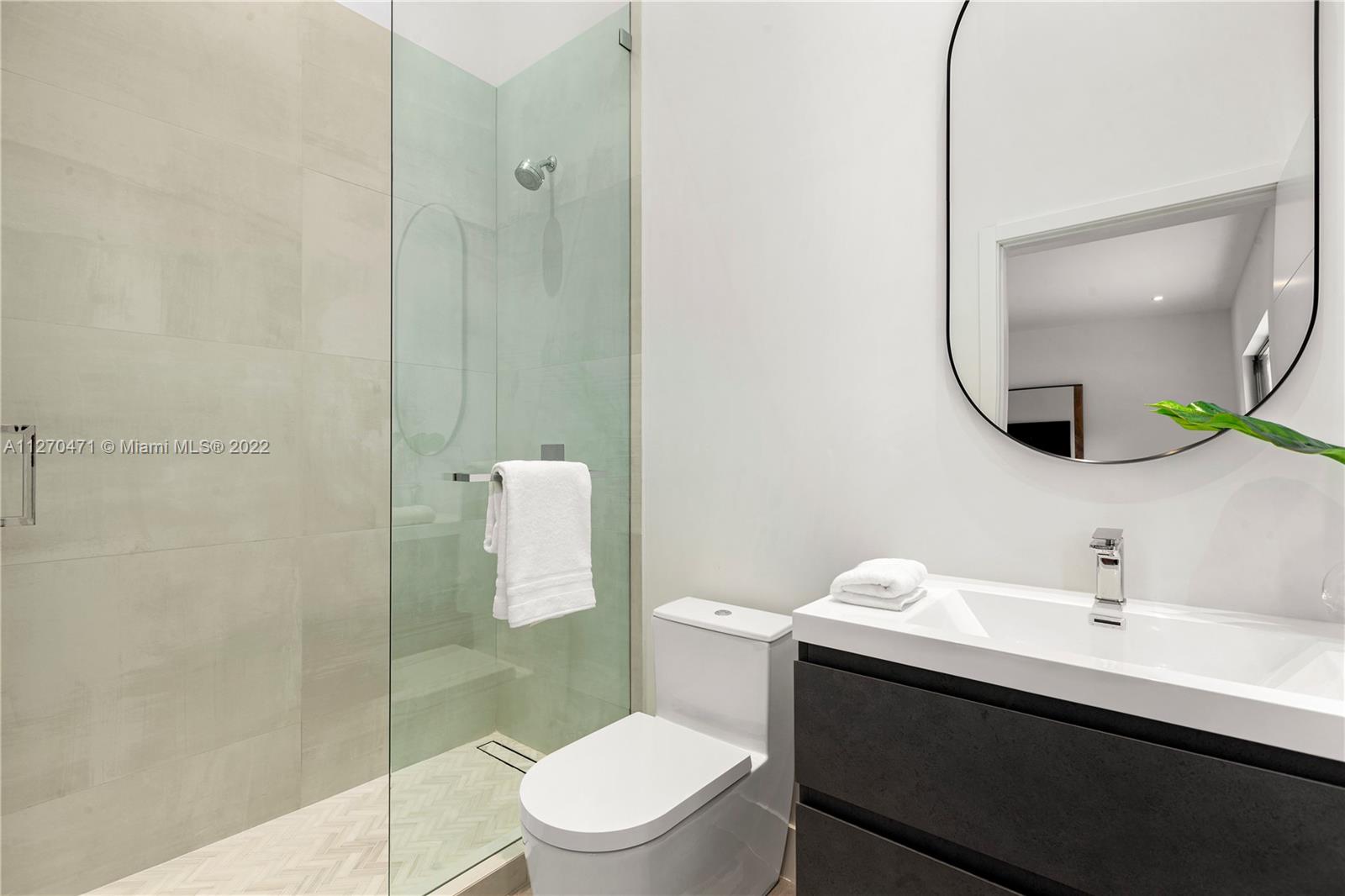 4095 Battersea Road Miami, FL 33133 - Photo 18 of 40 a bathroom with a toilet a sink and mirror