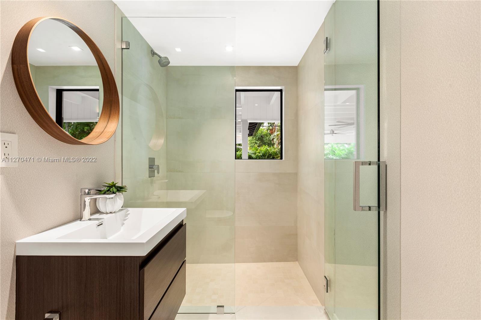 4095 Battersea Road Miami, FL 33133 - Photo 20 of 40 a bathroom with a sink a mirror a vanity and a shower