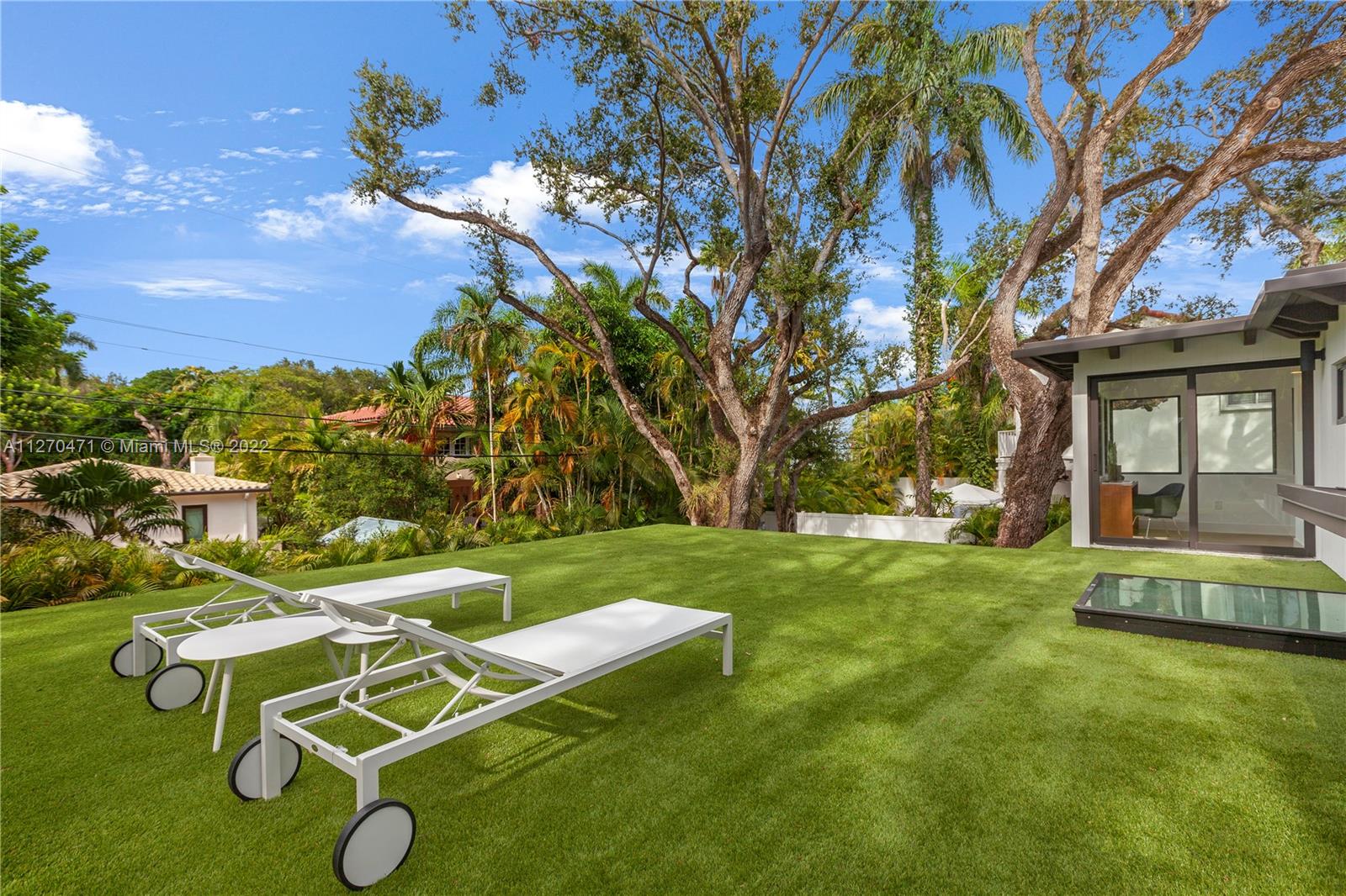 4095 Battersea Road Miami, FL 33133 - Photo 27 of 40 a backyard of a house with table and chairs