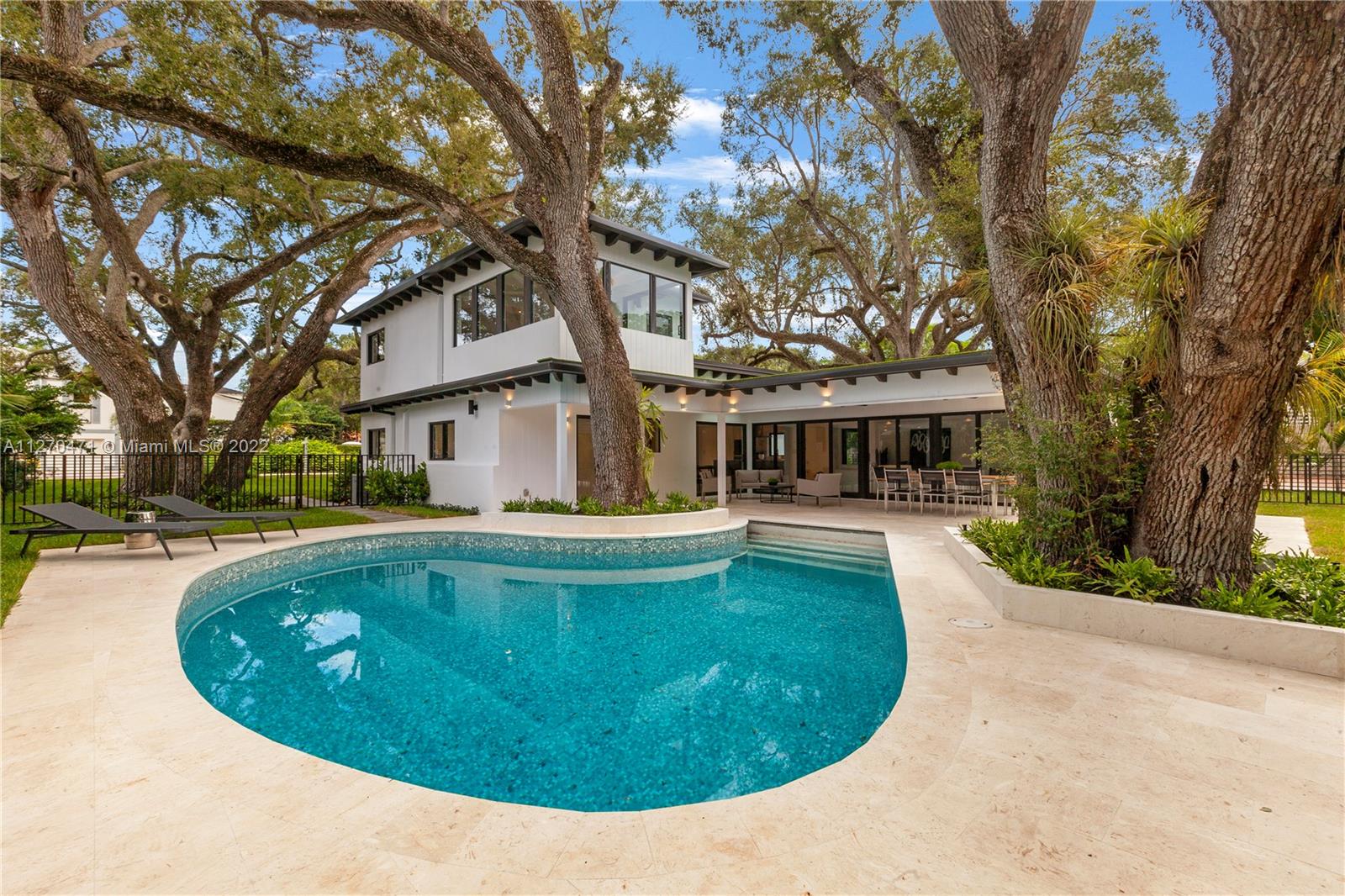 4095 Battersea Road Miami, FL 33133 - Photo 32 of 40 a view of house with swimming pool and a trees