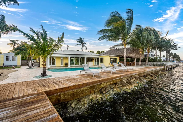 a view of a patio with table and chairs with wooden floor and fence