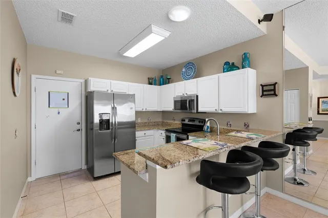 a kitchen with stainless steel appliances a stove a sink a microwave a stove and white cabinets