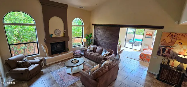 a living room with furniture fireplace and a large window