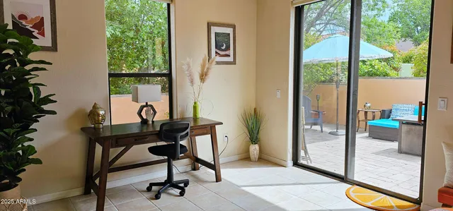a view of a workspace with furniture and a window