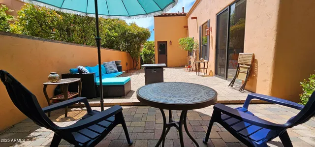 a outdoor dining space with furniture and umbrella