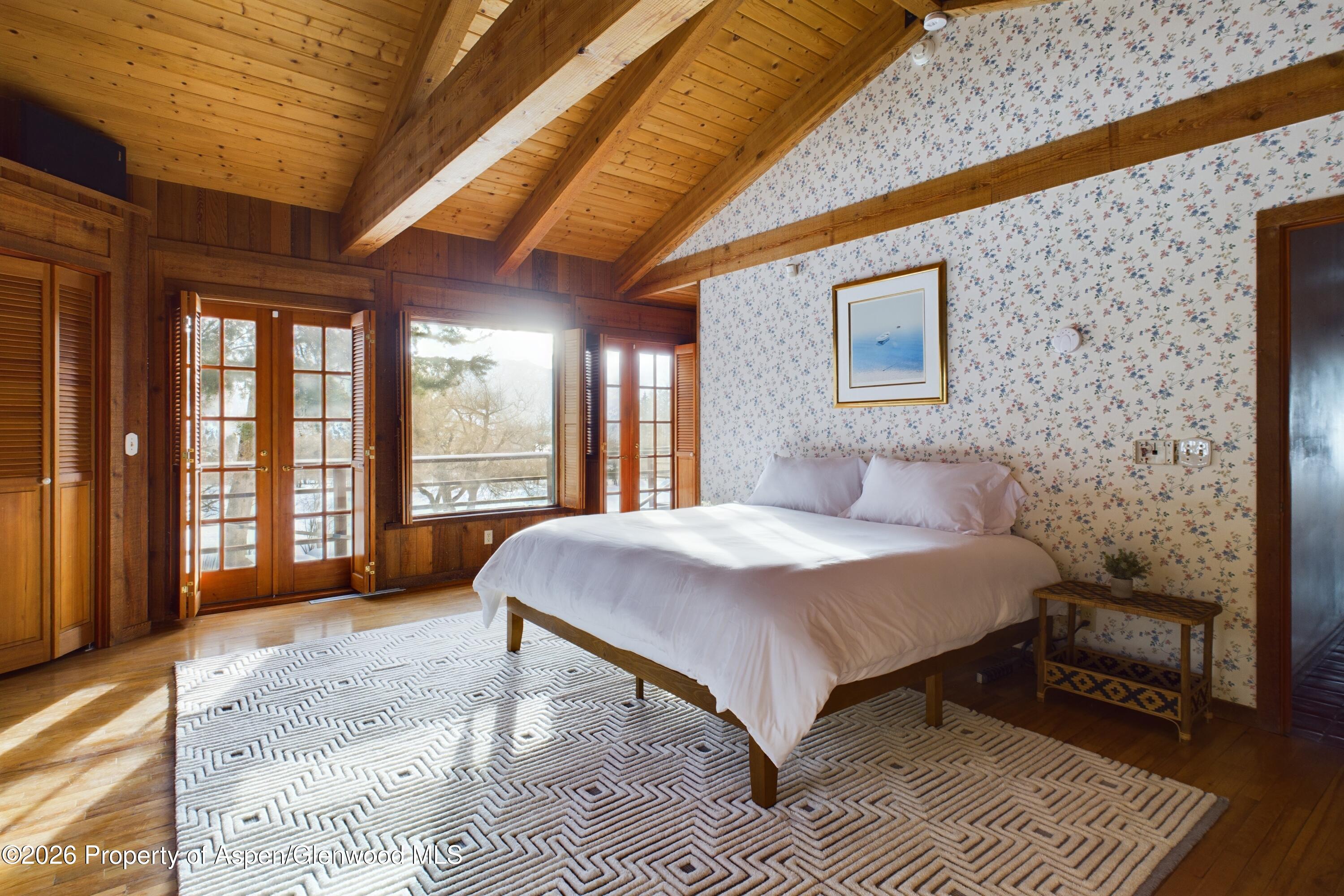 209 East Reds Road Aspen, CO 81612 - Photo 36 of 54 a bedroom with a bed wooden floor and window