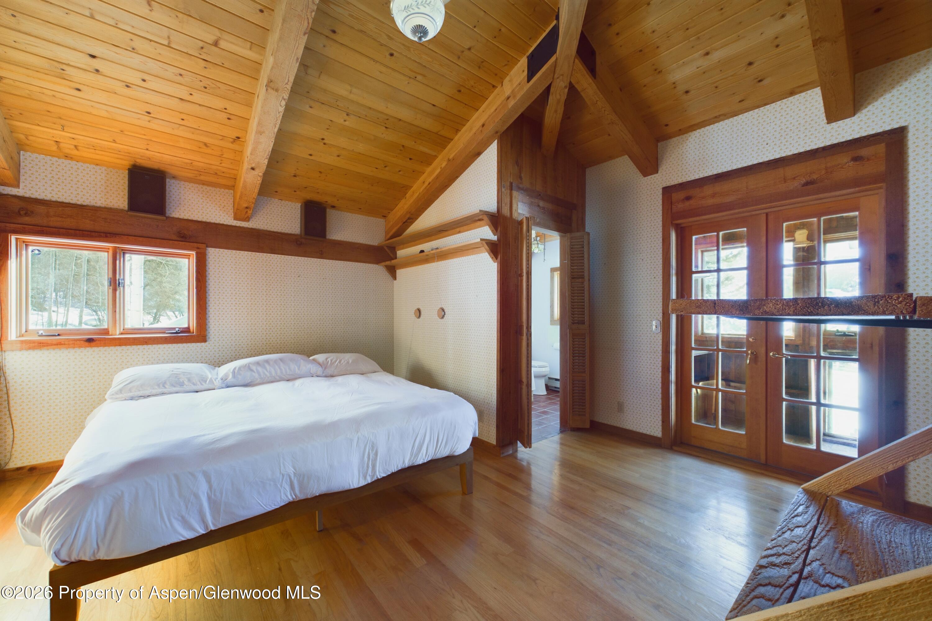 209 East Reds Road Aspen, CO 81612 - Photo 46 of 54 a bedroom with a bed and wooden floor