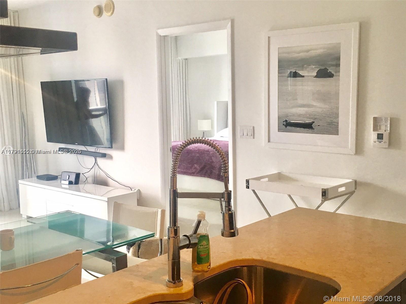 485 Brickell Avenue, Unit 1903 Miami, FL 33131 - Photo 3 of 8 a bathroom with a bathtub sink and mirror