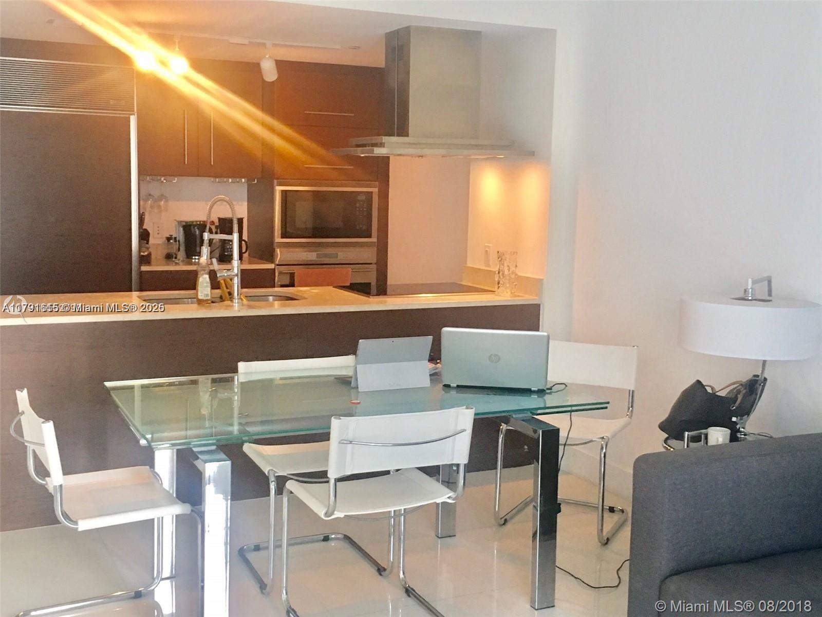 485 Brickell Avenue, Unit 1903 Miami, FL 33131 - Photo 4 of 8 a view of a dining room with furniture and wooden floor