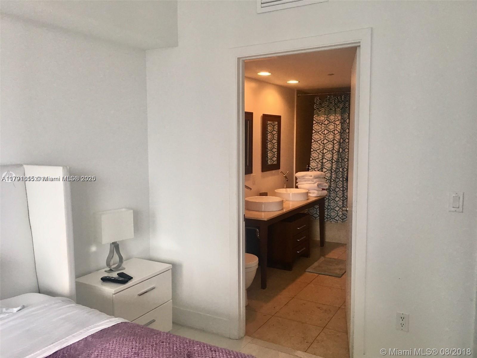 485 Brickell Avenue, Unit 1903 Miami, FL 33131 - Photo 5 of 8 a bathroom with a sink a toilet and mirror