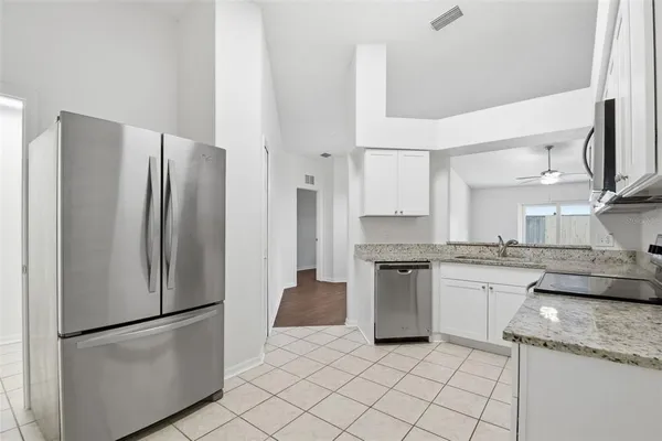 a kitchen with stainless steel appliances granite countertop a refrigerator and a stove