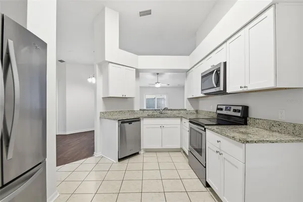 a kitchen with stainless steel appliances granite countertop a refrigerator and a stove top oven
