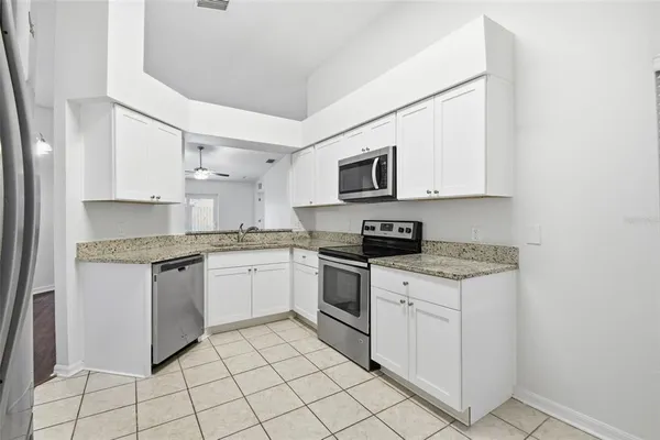a kitchen with white cabinets appliances and a sink