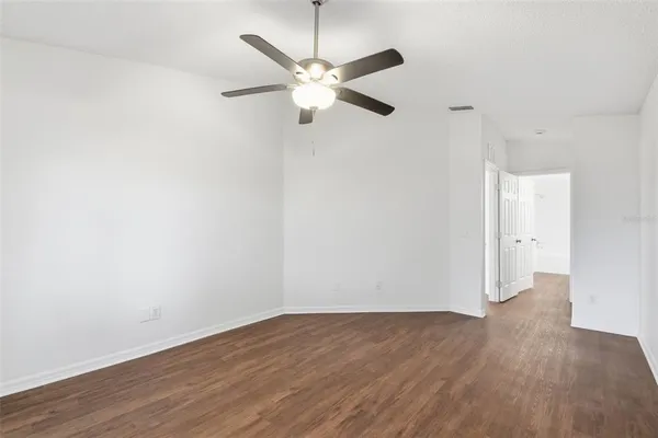 a view of a room with wooden floor and a ceiling fan