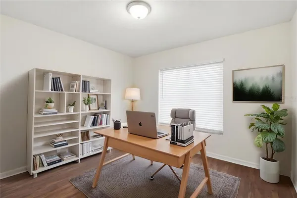 a view of a workspace with furniture and a window