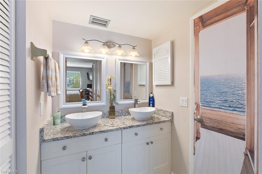 240 Palm Drive, Unit 481 Naples, FL 34112 - Photo 11 of 17 a bathroom with a granite countertop sink and a mirror