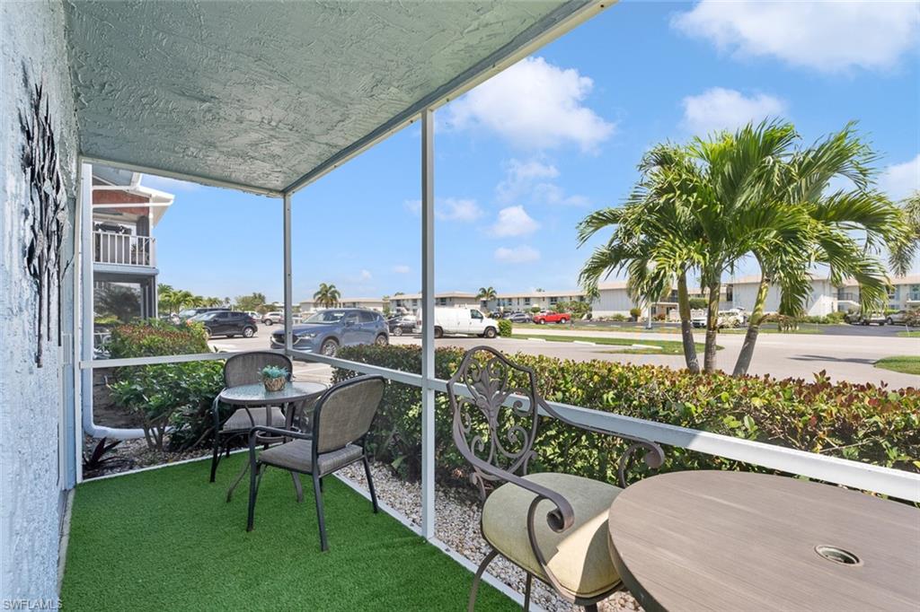 240 Palm Drive, Unit 481 Naples, FL 34112 - Photo 13 of 17 a view of a chair and tables in the patio