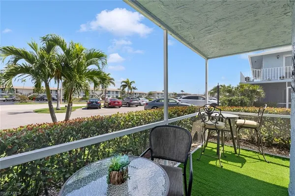 a view of balcony with chairs and potted plants