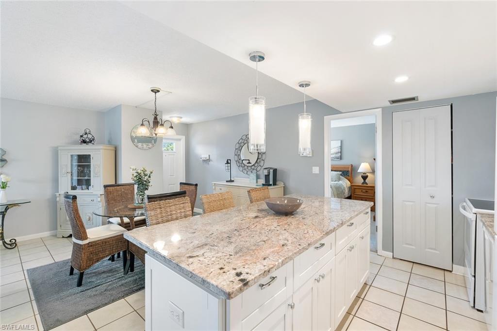 240 Palm Drive, Unit 481 Naples, FL 34112 - Photo 6 of 17 a kitchen with granite countertop sink and refrigerator