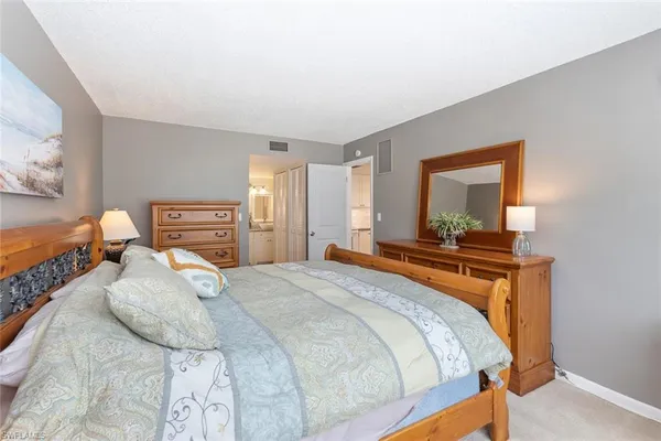 a bedroom with a bed and a dresser in it