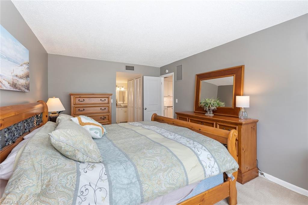 240 Palm Drive, Unit 481 Naples, FL 34112 - Photo 9 of 17 a bedroom with a bed and a dresser in it