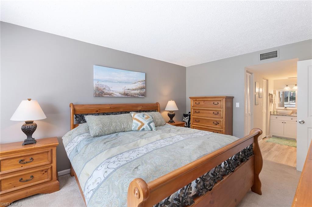 240 Palm Drive, Unit 481 Naples, FL 34112 - Photo 10 of 17 a bedroom with a bed and a lamp on dresser