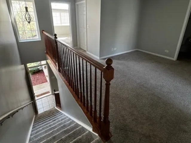 a view of a hallway with wooden floor and stairs